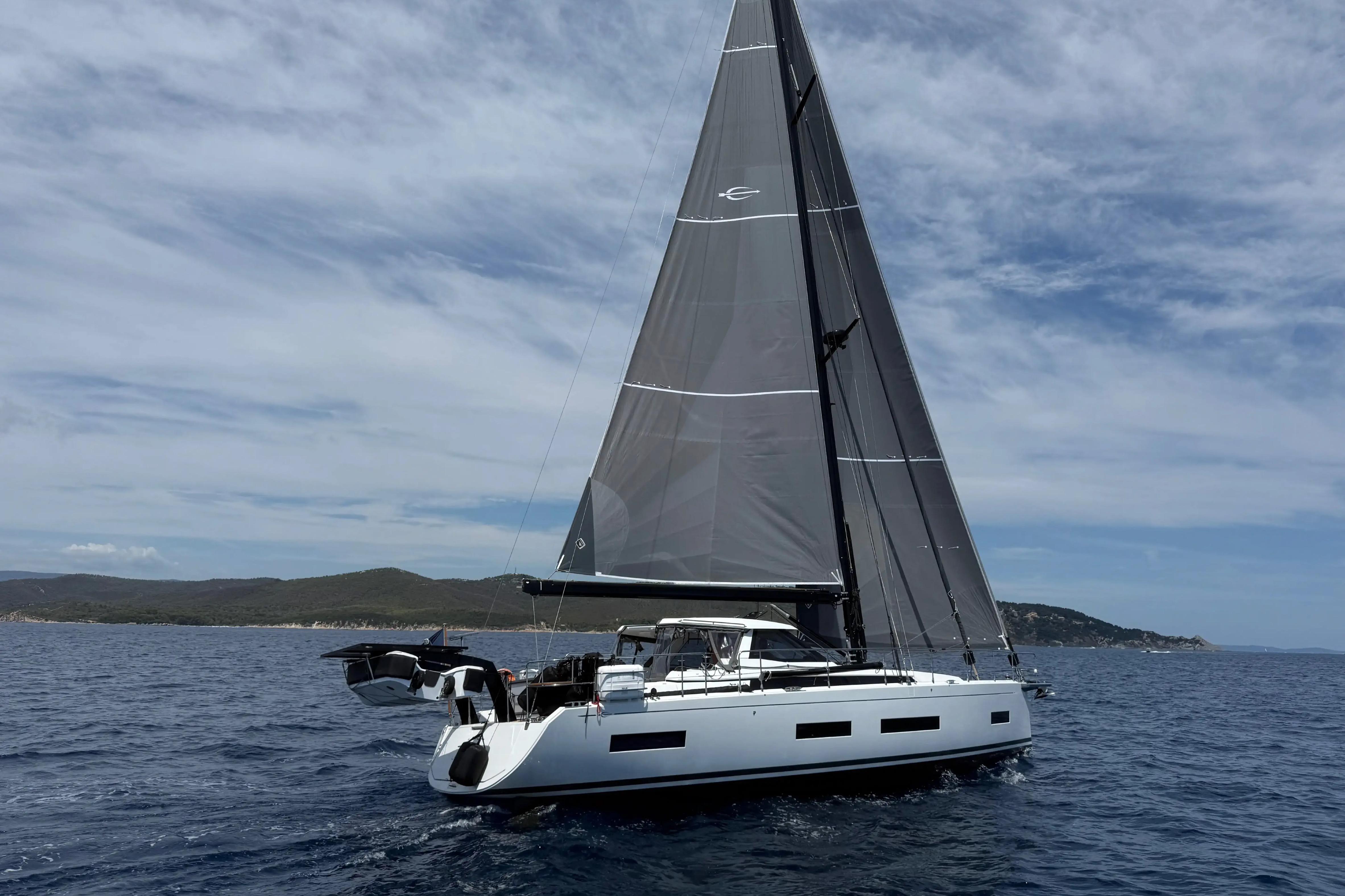 2025 Amel 50 yacht sailing on open sea under clear skies.