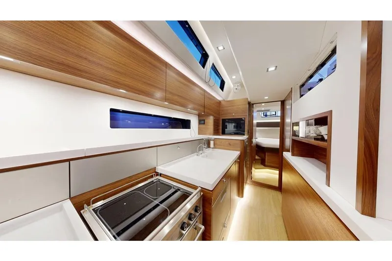 Yacht Photos Pics Luxurious interior of 2025 Amel 50 yacht featuring modern kitchen and sleek wood finishes.