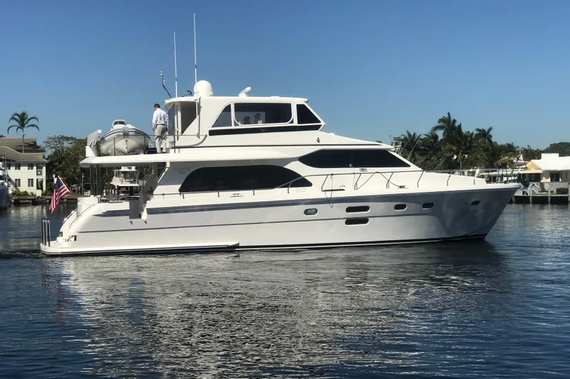 Bucephulas Yacht Photos Pics 2012 Hampton motor yacht cruising on a sunny day, surrounded by palm trees and waterfront homes.