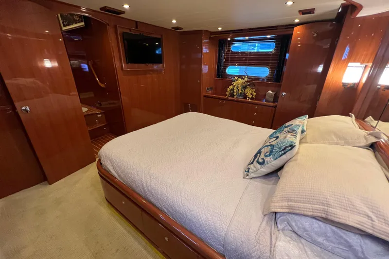 Bucephulas Yacht Photos Pics Luxurious bedroom interior of 2012 Hampton motor yacht with wood paneling and cozy bedding.