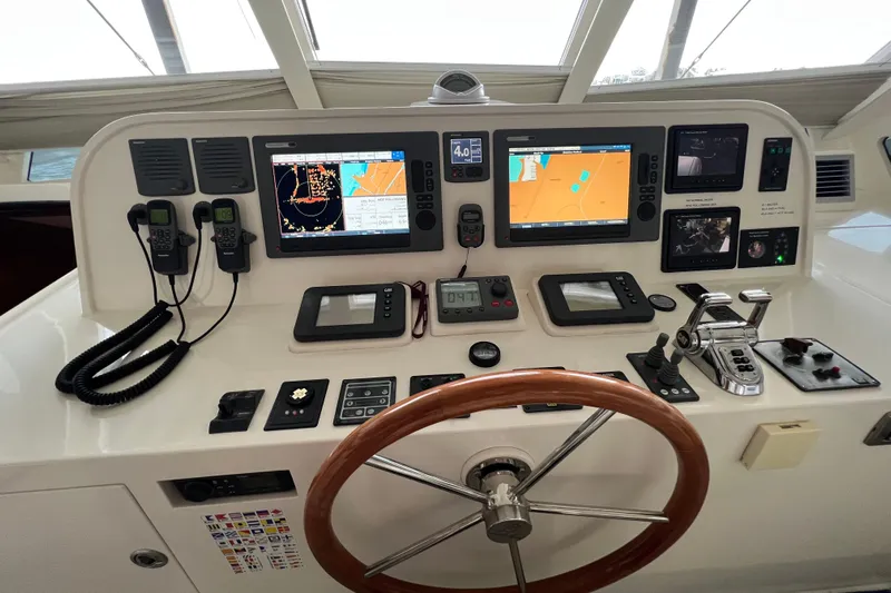 Bucephulas Yacht Photos Pics Control panel of a 2012 Hampton motor yacht with navigation screens and steering wheel.