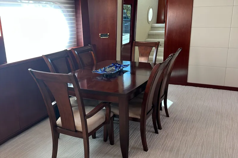Cecelia Mae Yacht Photos Pics Elegant dining area on 2015 Broward Raised Pilothouse M/Y yacht with wooden table and chairs.