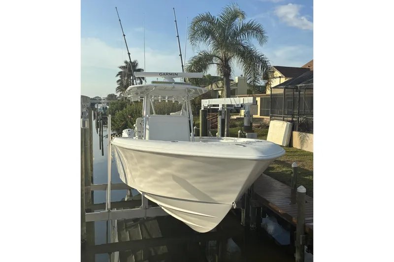  Yacht Photos Pics 2024 Contender 39 ST boat docked with fishing rods, palm trees in background.