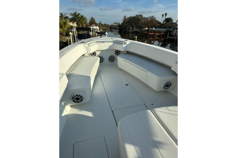  Yacht Photos Pics 2024 Contender 39 ST boat interior with seating and speakers, docked by a canal.