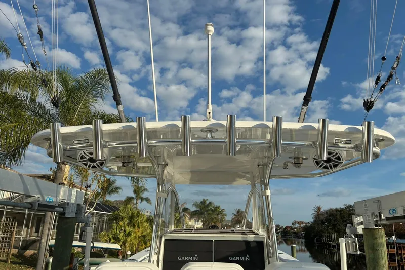  Yacht Photos Pics 2024 Contender 39 ST boat with rod holders and speakers, docked under a blue sky.