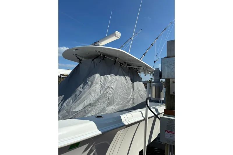  Yacht Photos Pics 2024 Contender 39 ST boat with covered console and fishing rods, docked under clear blue sky.