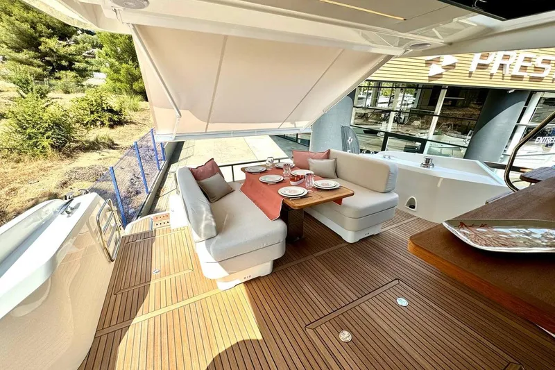  Yacht Photos Pics Luxurious 2026 Prestige F4.9 yacht deck with elegant dining setup and comfortable seating.