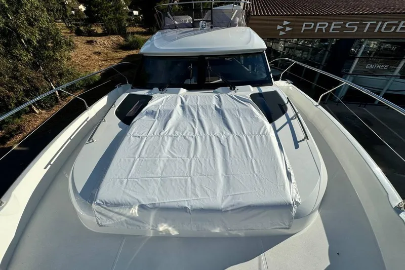  Yacht Photos Pics 2026 Prestige F4.9 yacht with covered deck, docked near showroom.