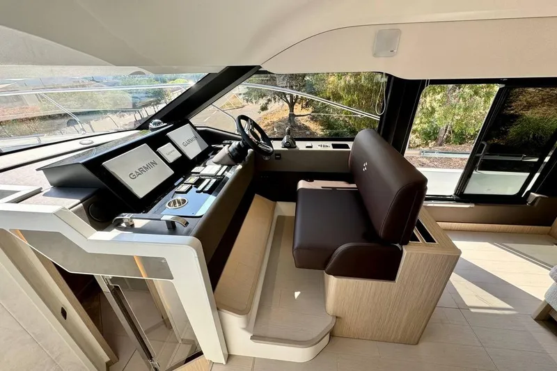  Yacht Photos Pics Luxurious 2026 Prestige F4.9 yacht helm with Garmin navigation displays and plush seating.