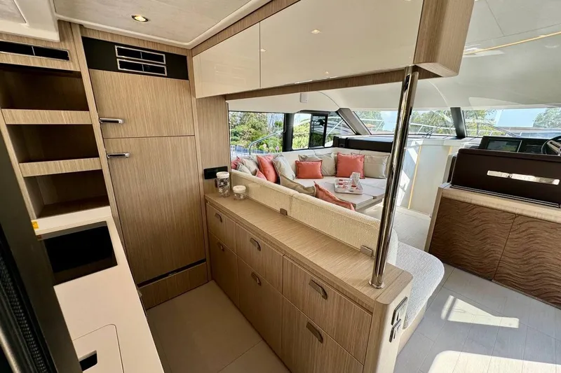  Yacht Photos Pics Luxurious 2026 Prestige F4.9 yacht interior with modern wood cabinetry and plush seating.