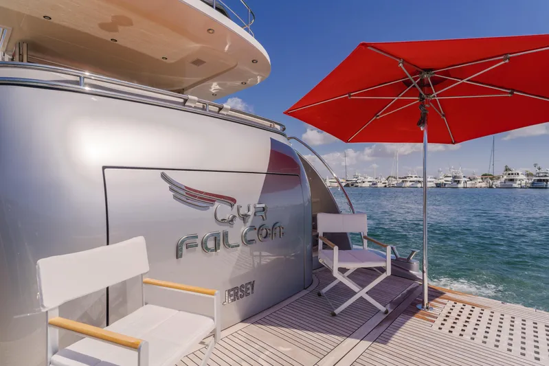 Gyrfalcon Yacht Photos Pics Van der Valk 78 Flybridge Motor Yacht 2016, docked with chairs and red umbrella.