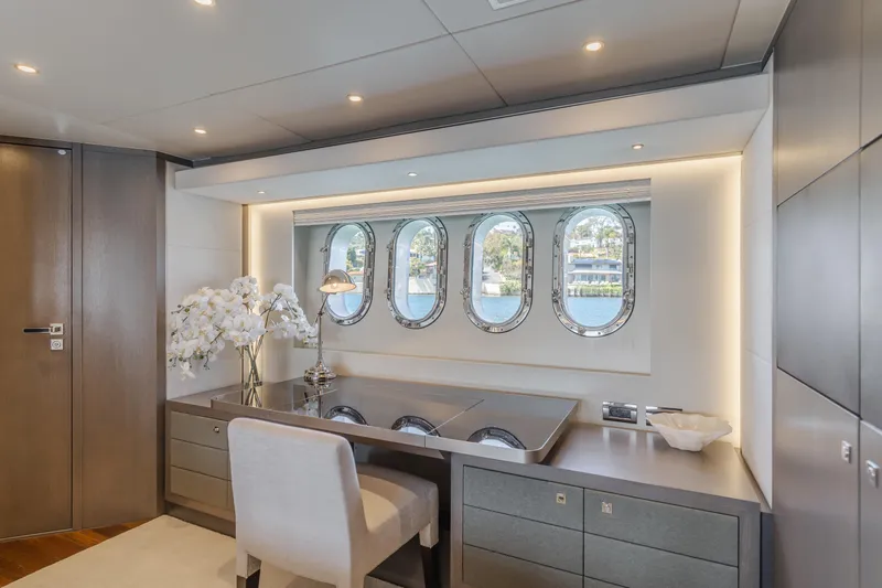 Gyrfalcon Yacht Photos Pics Luxurious interior of 2016 Van der Valk 78 Flybridge Motor Yacht with elegant desk and porthole windows.