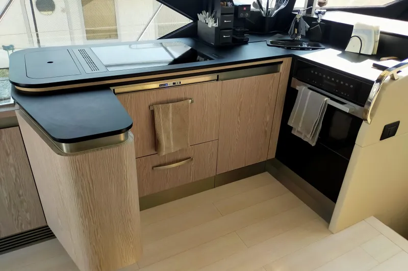  Yacht Photos Pics Modern kitchen interior on 2023 Azimut S6 Sportfly yacht, featuring sleek appliances and wood cabinetry.