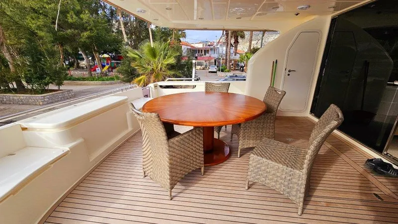 Yacht Photos Pics Outdoor dining area on 2012 Ferretti Yachts 881 with round table and wicker chairs.