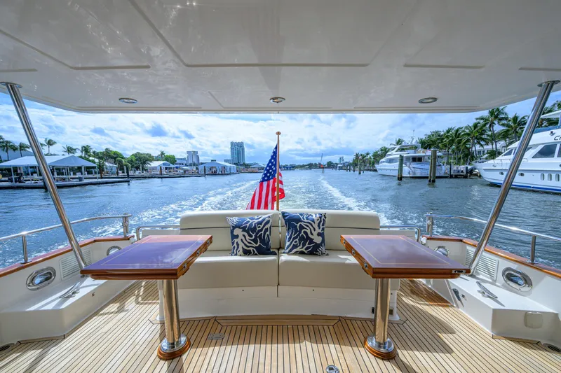 Monkey Business Yacht Photos Pics Grand Banks 59 Aleutian RP 2007 yacht deck with seating, tables, and American flag.