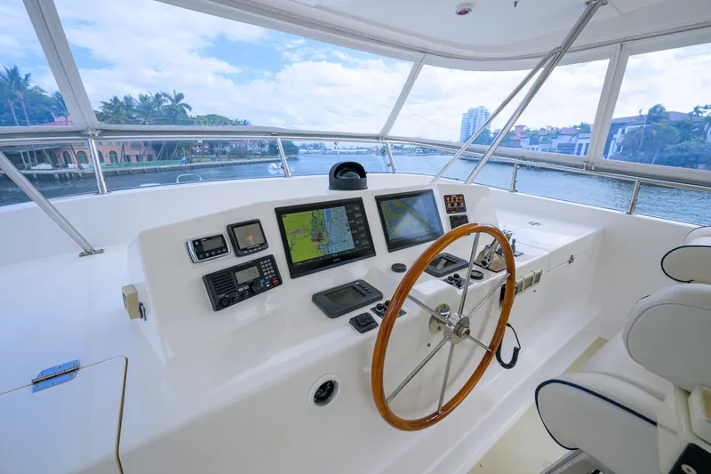 Monkey Business Yacht Photos Pics Helm of 2007 Grand Banks 59 Aleutian RP yacht with navigation equipment and wooden steering wheel.