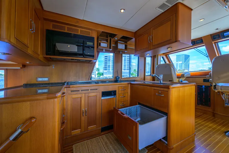 Monkey Business Yacht Photos Pics Luxurious 2007 Grand Banks 59 Aleutian RP yacht kitchen with wood cabinetry and modern appliances.