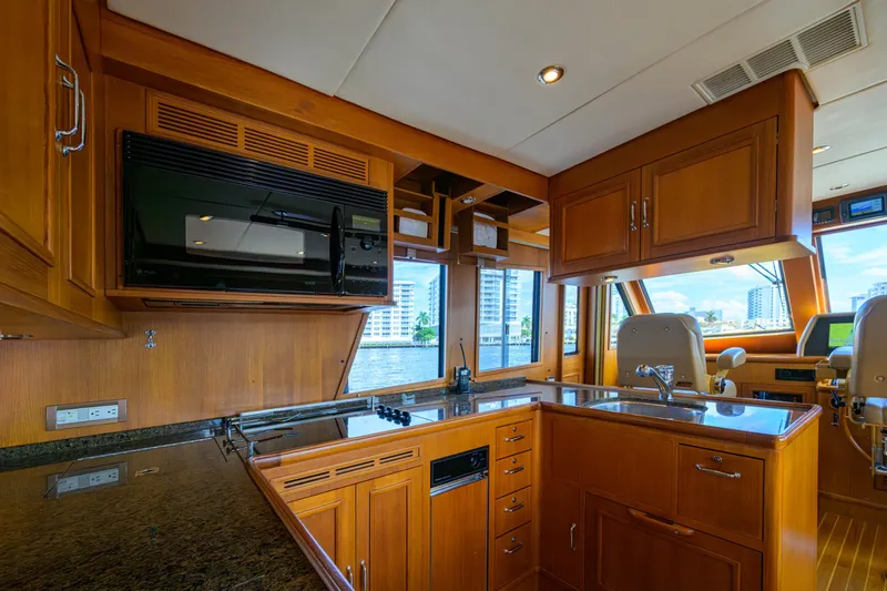 Monkey Business Yacht Photos Pics Luxurious 2007 Grand Banks 59 Aleutian RP yacht kitchen with wood cabinetry and modern appliances.