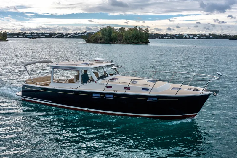 Handful Yacht Photos Pics 2014 MJM 40z yacht cruising on serene waters under a cloudy sky.