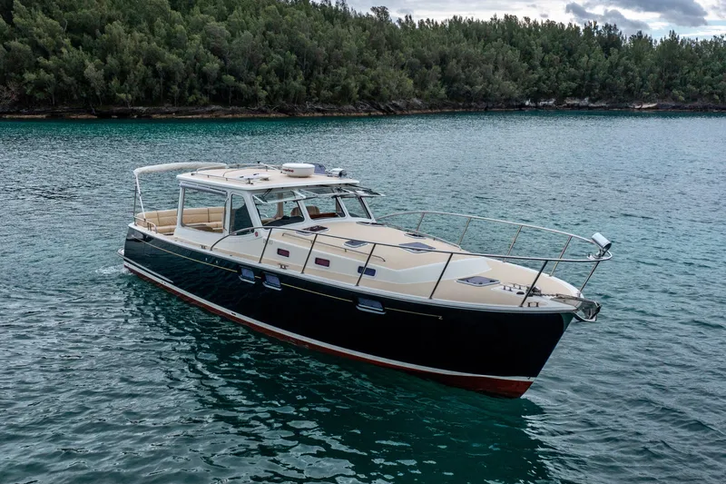 Handful Yacht Photos Pics 2014 MJM 40z yacht on serene water with lush forest backdrop.