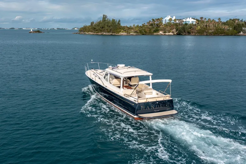 Handful Yacht Photos Pics 2014 MJM 40z yacht cruising on serene blue waters near a lush island.