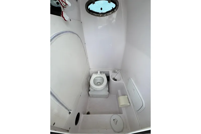  Yacht Photos Pics 2018 Fountain 34 Center Console boat bathroom with toilet and porthole window.