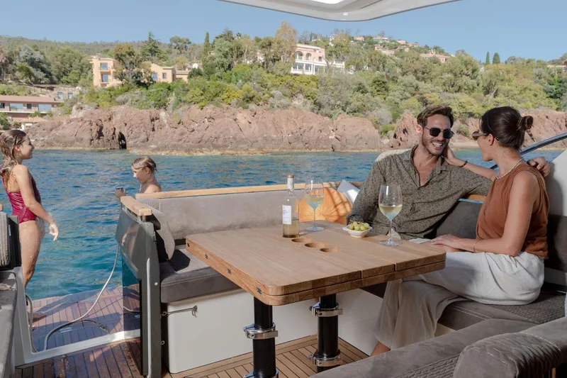  Yacht Photos Pics Couple enjoying drinks on a 2026 Marex 390 yacht, with scenic coastal backdrop.