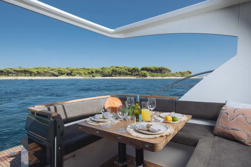  Yacht Photos Pics Luxury dining setup on Marex 390 yacht, 2026 model, with ocean and island view.