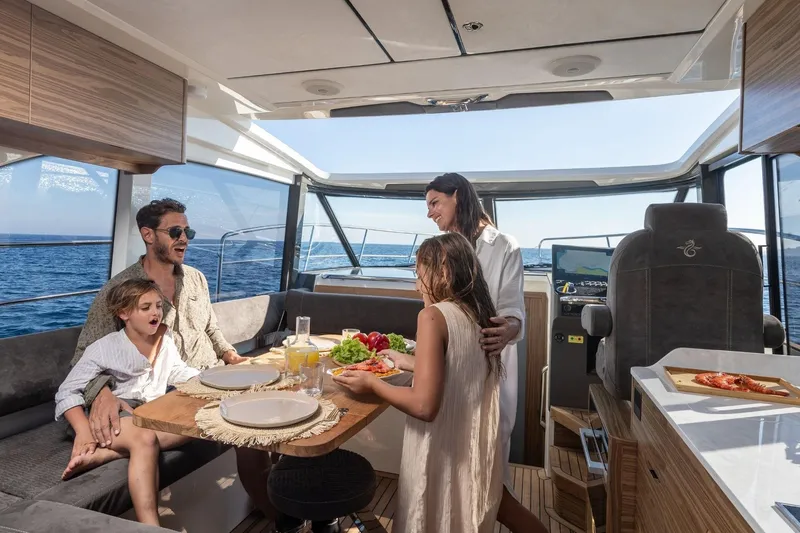  Yacht Photos Pics Family enjoying a meal on a 2026 Marex 390 yacht, with ocean views.