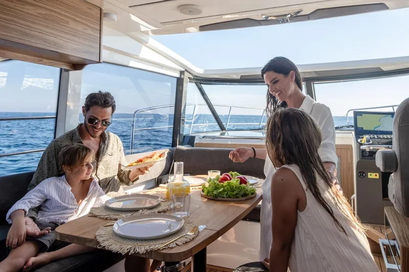  Yacht Photos Pics Family enjoying a meal on a 2026 Marex 390 yacht, with ocean views.