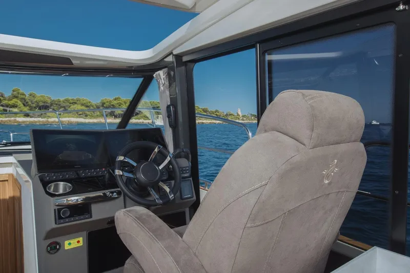  Yacht Photos Pics Interior view of 2026 Marex 390 boat cockpit with steering wheel and navigation screen.