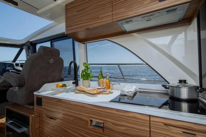  Yacht Photos Pics Luxurious Marex 390 yacht kitchen with ocean view, featuring modern appliances and elegant wood finish.