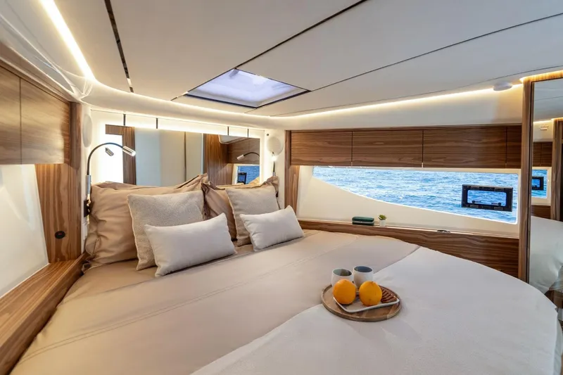  Yacht Photos Pics Luxurious cabin interior of 2026 Marex 390 yacht with ocean view and cozy bedding.