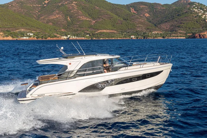  Yacht Photos Pics 2026 Marex 390 yacht cruising on blue ocean with scenic mountain backdrop.