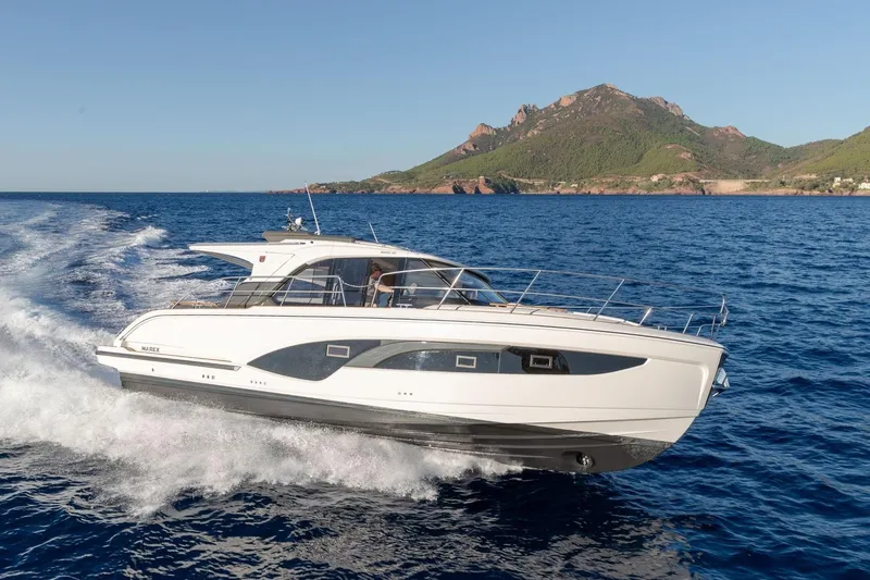  Yacht Photos Pics 2026 Marex 390 yacht cruising on blue ocean with scenic mountain backdrop.