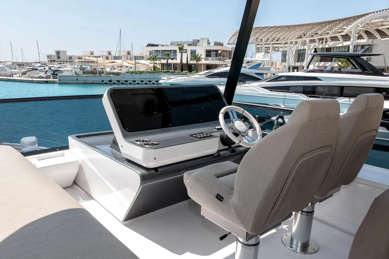  Yacht Photos Pics 2024 Azimut 68 yacht helm with modern controls and luxurious seating at a marina.