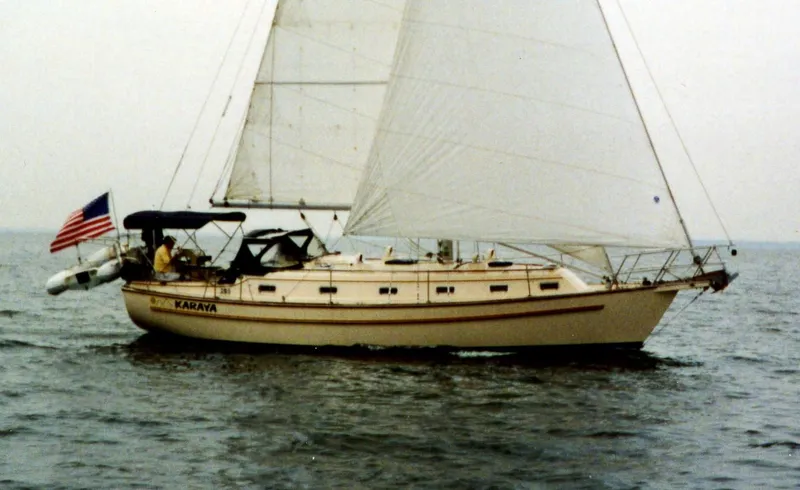 Karaya Yacht Photos Pics Island Packet 40 sailboat from 1995 sailing on open water with American flag.