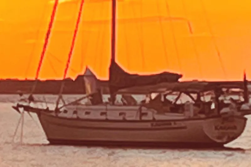 Karaya Yacht Photos Pics Sailboat Island Packet 40, 1995 model, silhouetted against a vibrant orange sunset.