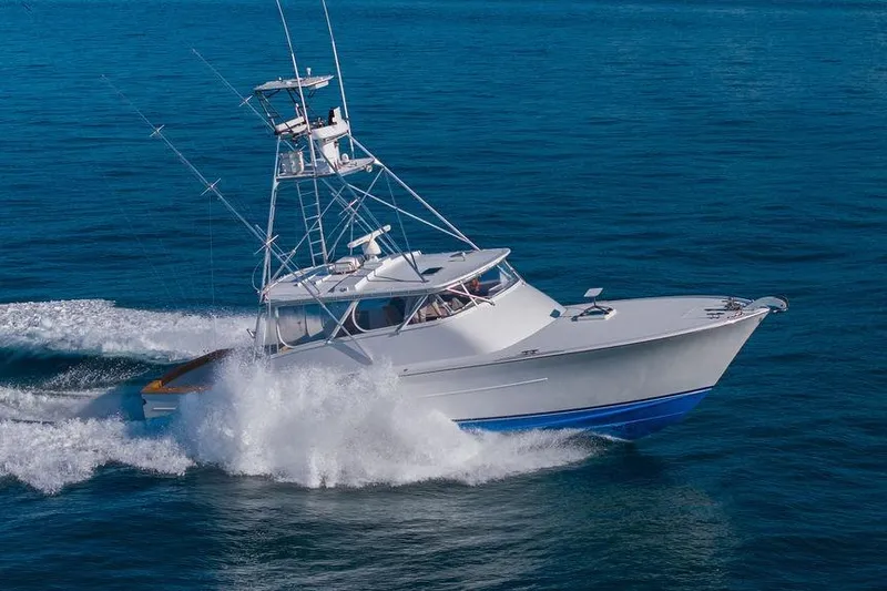 Chunda Yacht Photos Pics 1998 Merritt 48 yacht cruising on open blue water, creating a dynamic wake.