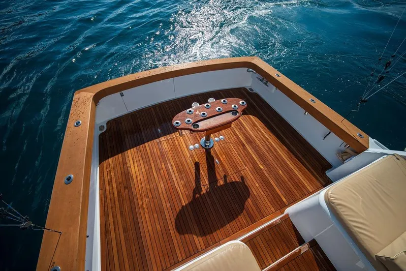 Chunda Yacht Photos Pics Merritt 48 yacht deck, 1998 model, with polished wood finish and ocean backdrop.