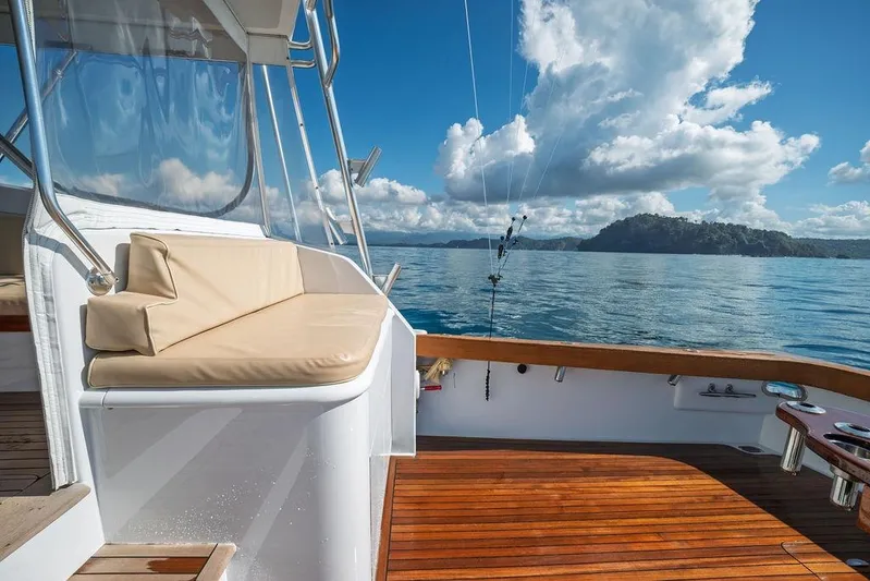 Chunda Yacht Photos Pics Luxury Merritt 48 yacht deck with ocean view, 1998 model, clear skies, and island backdrop.