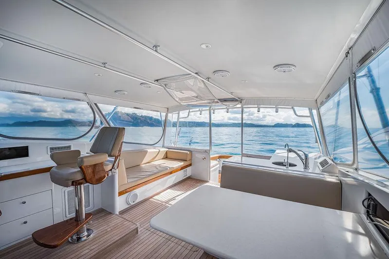 Chunda Yacht Photos Pics Luxurious 1998 Merritt 48 yacht interior with ocean view, featuring seating and helm station.