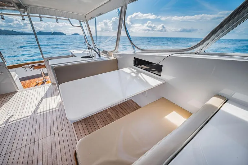 Chunda Yacht Photos Pics Luxurious Merritt 48 yacht interior with ocean view, featuring sleek seating and a modern table.
