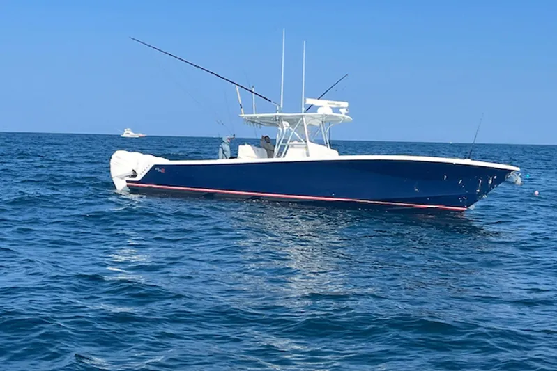 Showtime Yacht Photos Pics 2015 SeaVee 390Z boat on open ocean, blue hull, fishing rods visible.