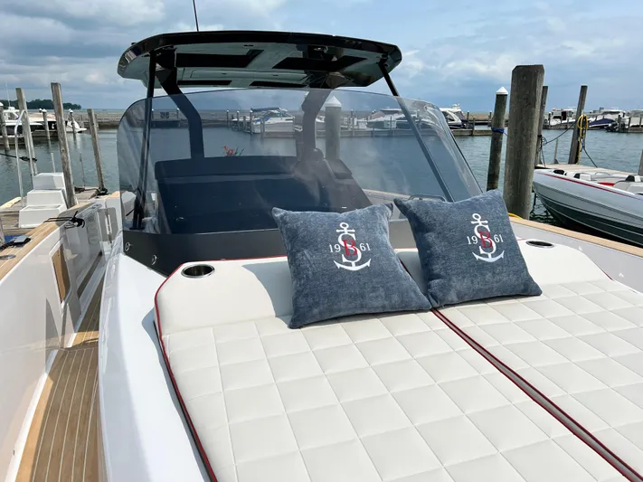  Yacht Photos Pics 2023 Pardo Yachts 38 Outboard with cushioned deck and nautical-themed pillows at a marina.