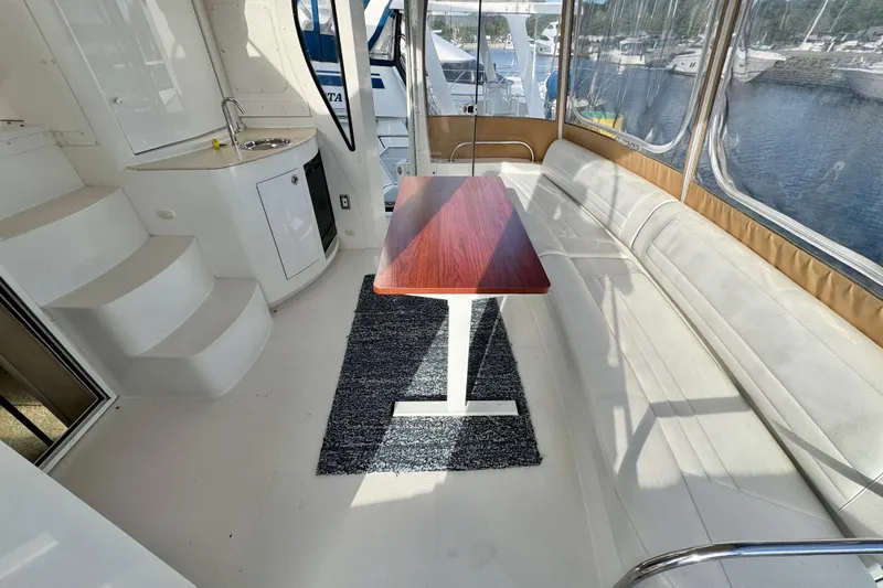 Water Music Yacht Photos Pics 2006 Carver 43 Motor Yacht interior with seating, table, and kitchenette, overlooking marina.