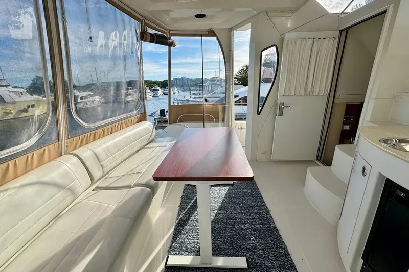 Water Music Yacht Photos Pics Interior of 2006 Carver 43 Motor Yacht with seating, table, and marina view.