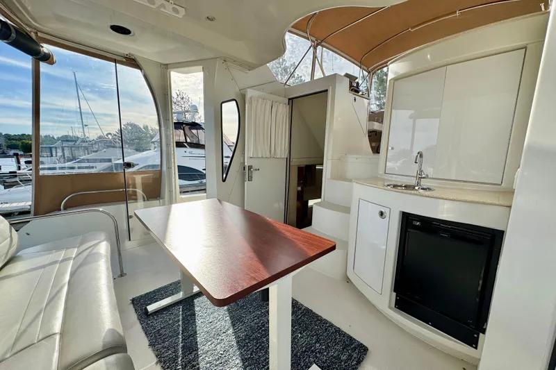 Water Music Yacht Photos Pics Interior of 2006 Carver 43 Motor Yacht with seating, table, and kitchenette.