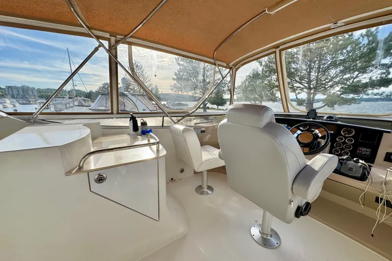 Water Music Yacht Photos Pics Interior view of 2006 Carver 43 Motor Yacht helm with scenic marina backdrop.