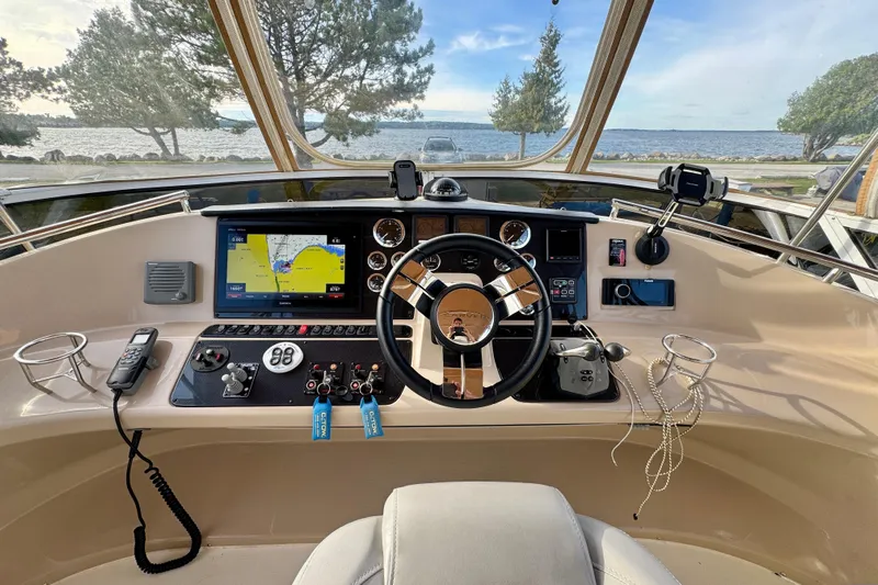 Water Music Yacht Photos Pics 2006 Carver 43 Motor Yacht helm with navigation system, steering wheel, and scenic water view.